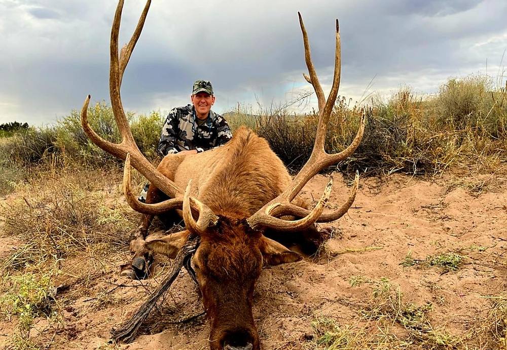 Hunter with a mature bull elk on an overcast New Mexico afternoon